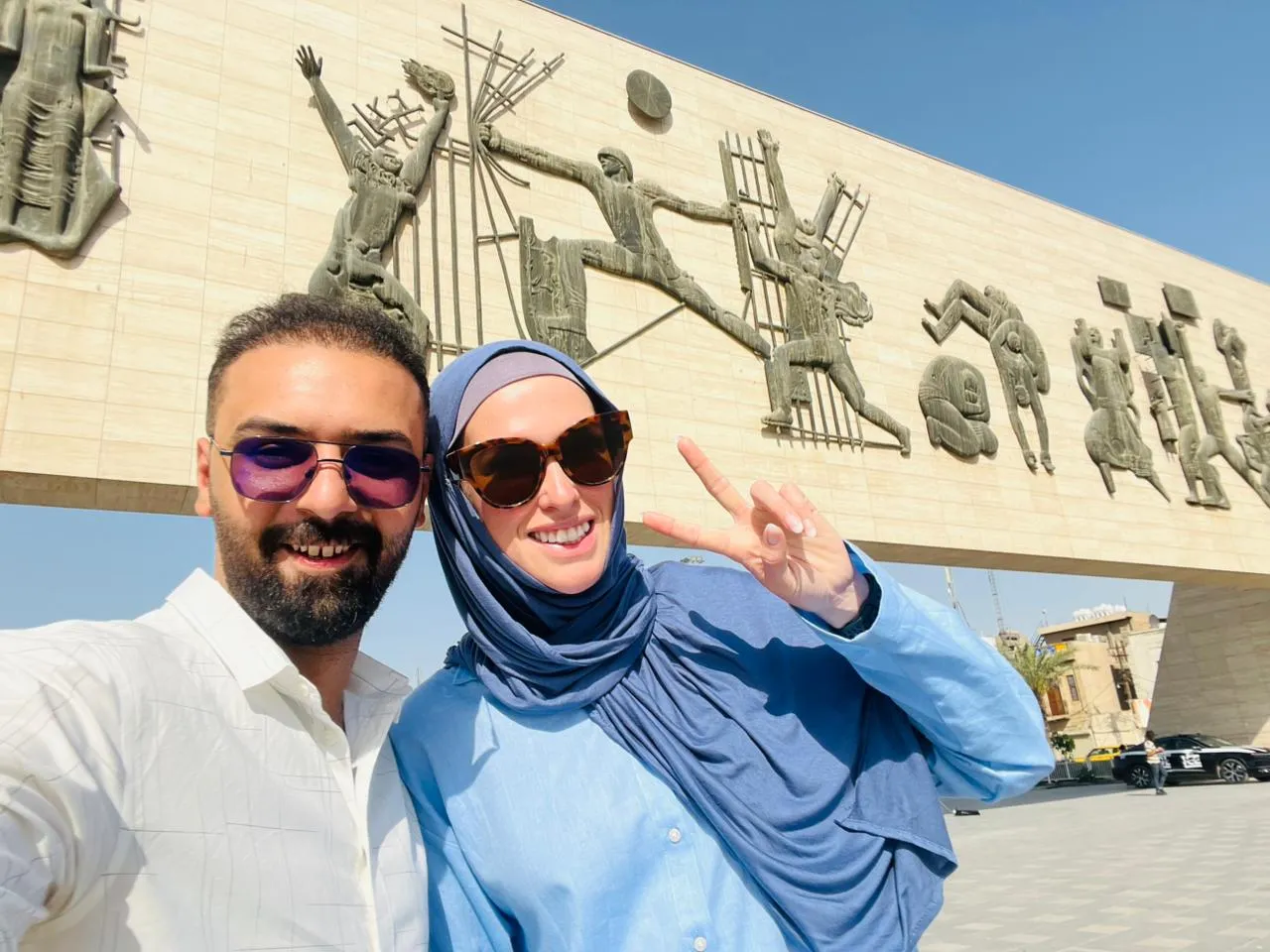 A couple photographed under the long bronze frieze of the Liberation Monument on Tahrir Square, Baghdad.